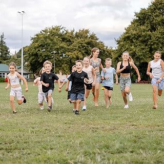 NZ kids running and jumping in colourful Outplay activewear — confidence in motion.
