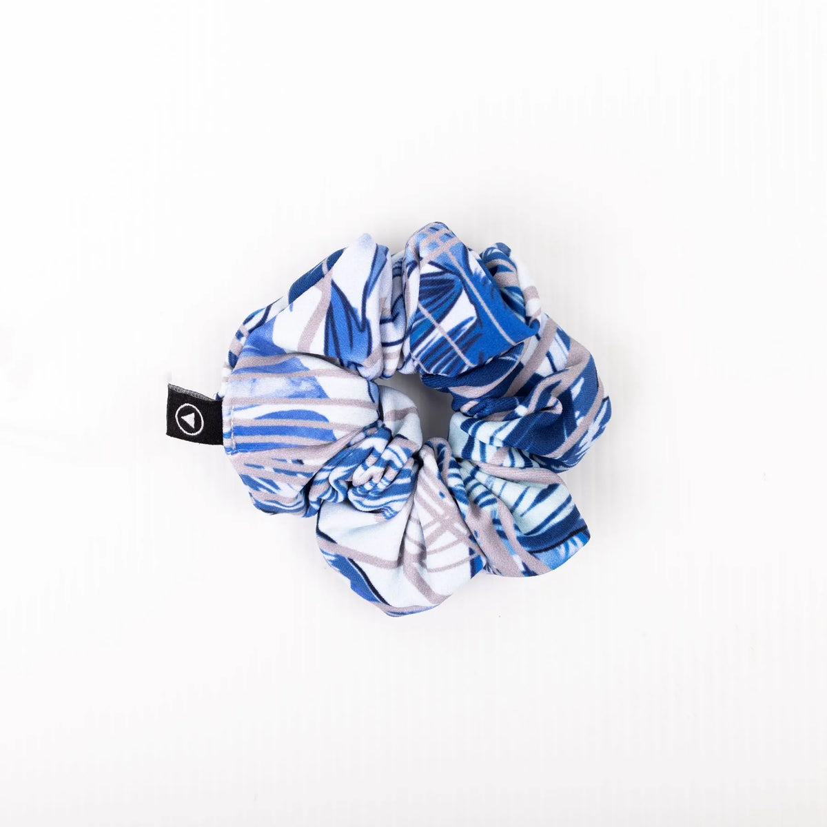 Scrunchie in Blue Monstera pattern on a plain white background