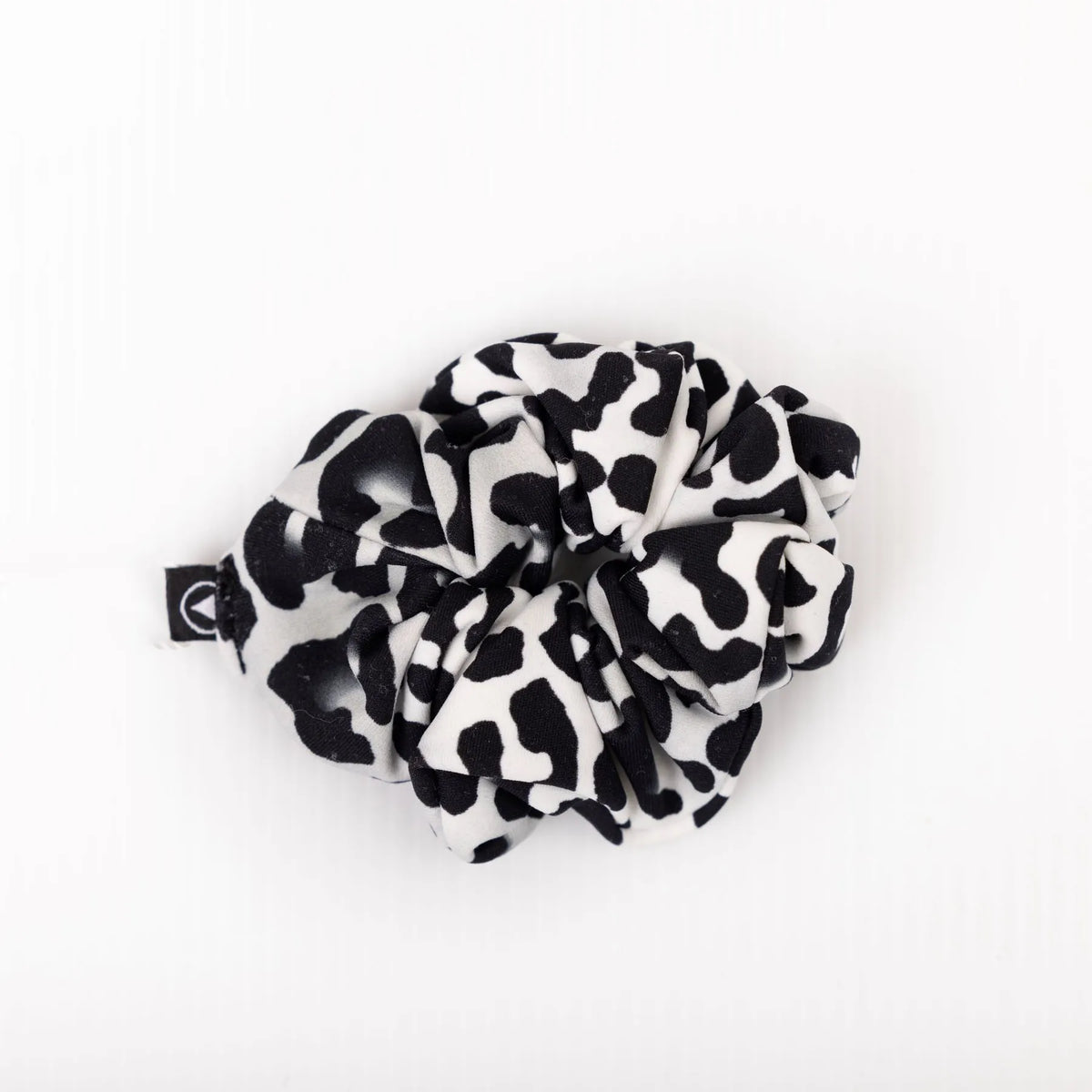 Scrunchie in black and white Snow Leopard print on a plain white background