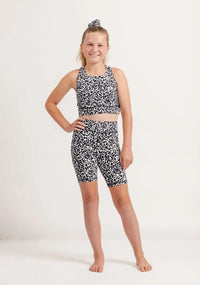Young girl wearing Snow Leopard print sports outfit on a white background
