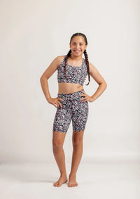 Girl wearing an Envy Me Multi coloured leopard print crop and Get Moving bike shorts set on a white background