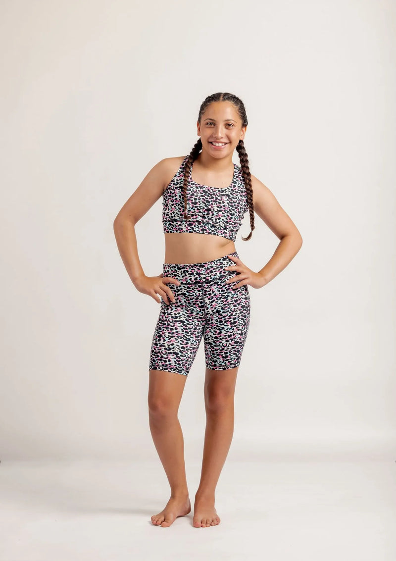Girl wearing an Envy Me Multi coloured leopard print crop and Get Moving bike shorts set on a white background