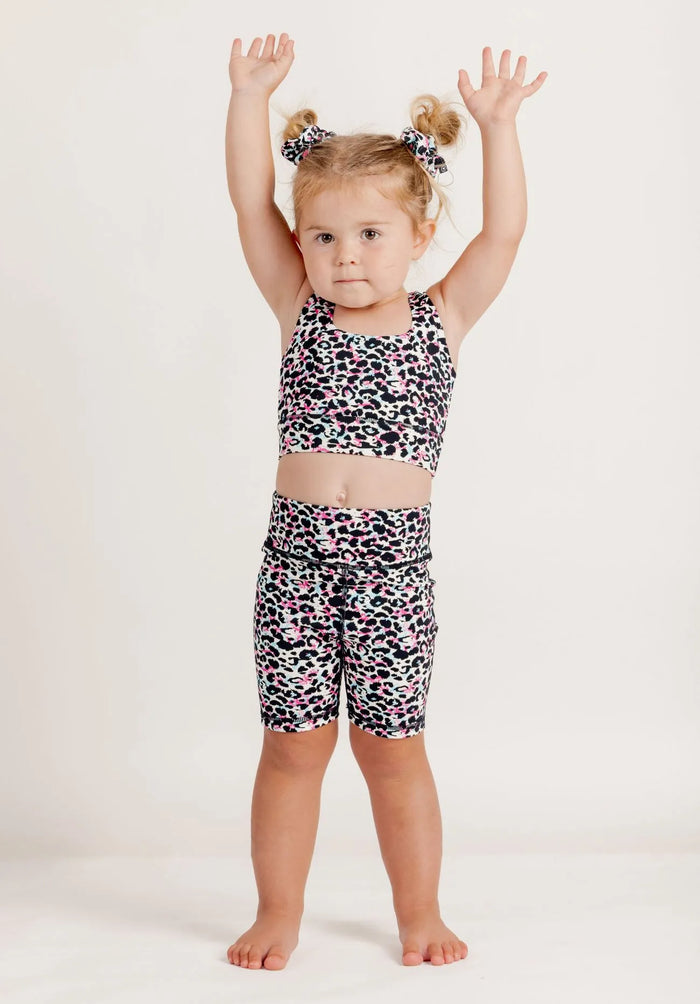 Girl wearing an Envy Me Multi coloured leopard print crop and Get Moving bike shorts set on a white background