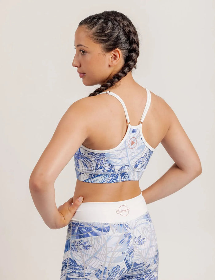 Girl wearing a Fearless Blue Monstera patterned crop and Limitless leggings on a plain background