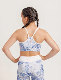 Girl wearing a Fearless Blue Monstera patterned crop and Limitless leggings on a plain background