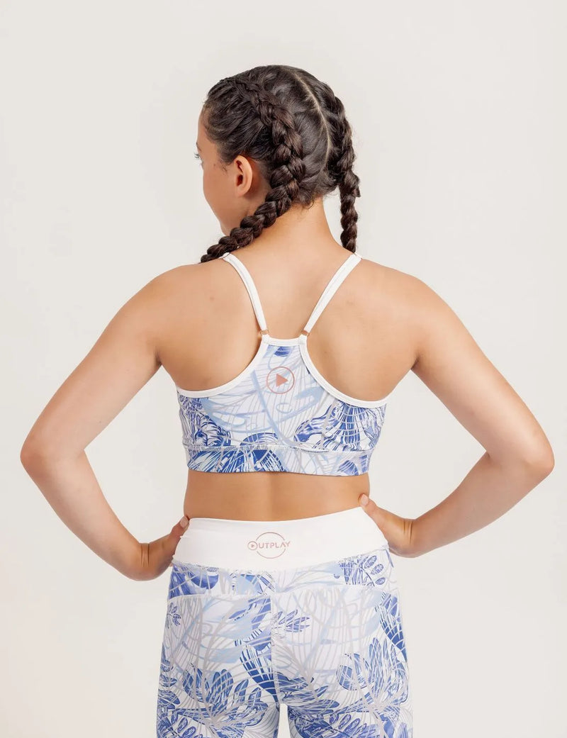Girl wearing a Fearless Blue Monstera patterned crop and Limitless leggings on a plain background