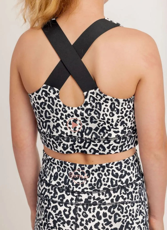 Ignite Snow Leopard print crop top with black straps on a plain background