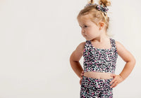 Young girl wearing an Envy Me Multi coloured leopard print crop and bike shorts set on a white background