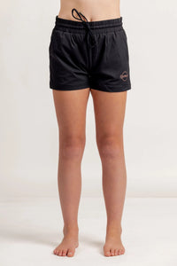 Girl in black jogger shorts on a light background