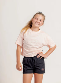 Girl in a light t shirt and black jogger shorts on a light background