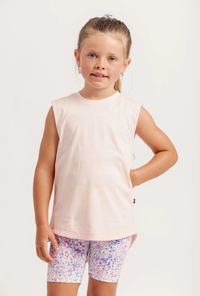 Young girl wearing a Shine Bright sleeveless top and Get Moving Floral shorts on a white background