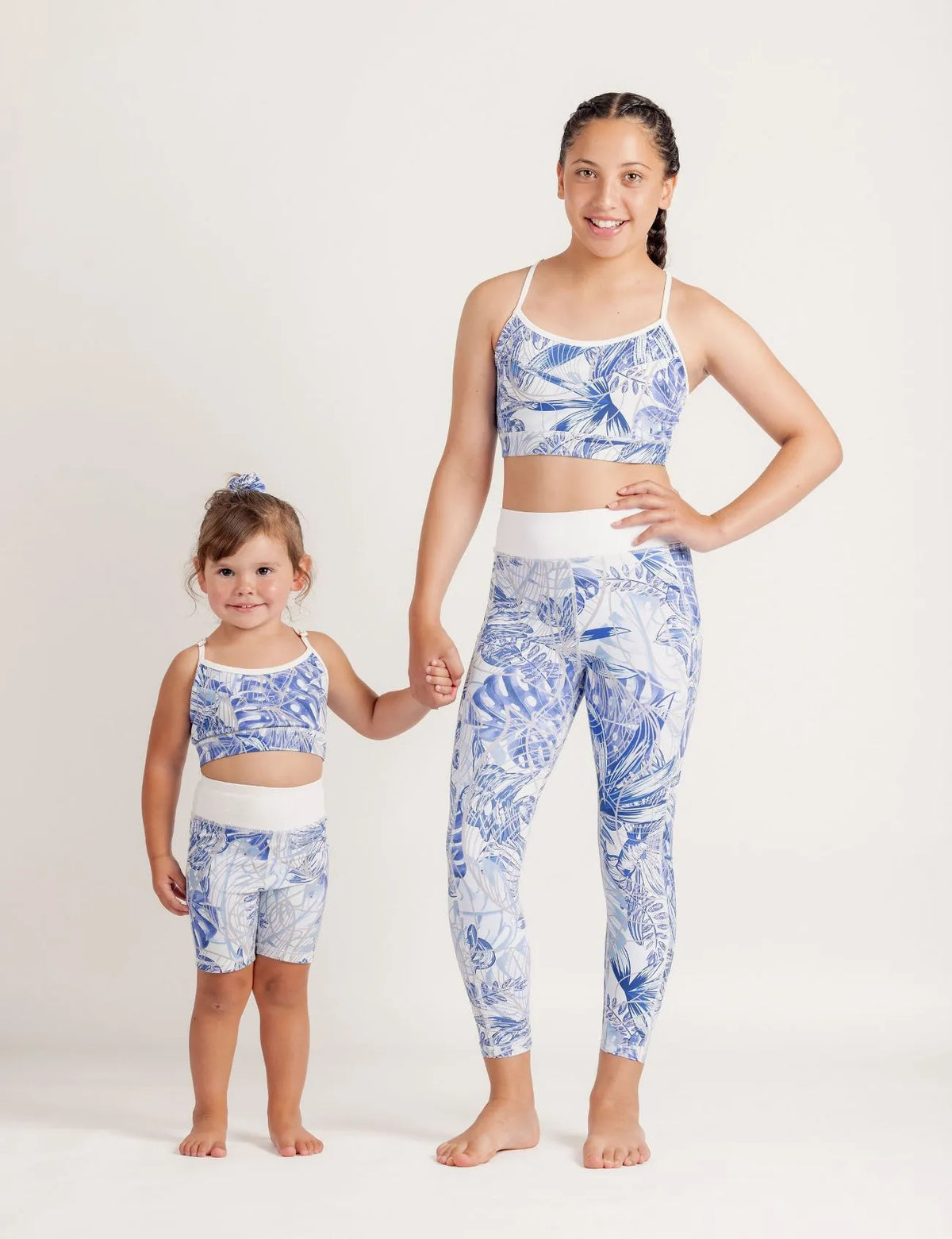 Two girls wearing Blue Monstera Crop top and Limitless leggings set on a light background