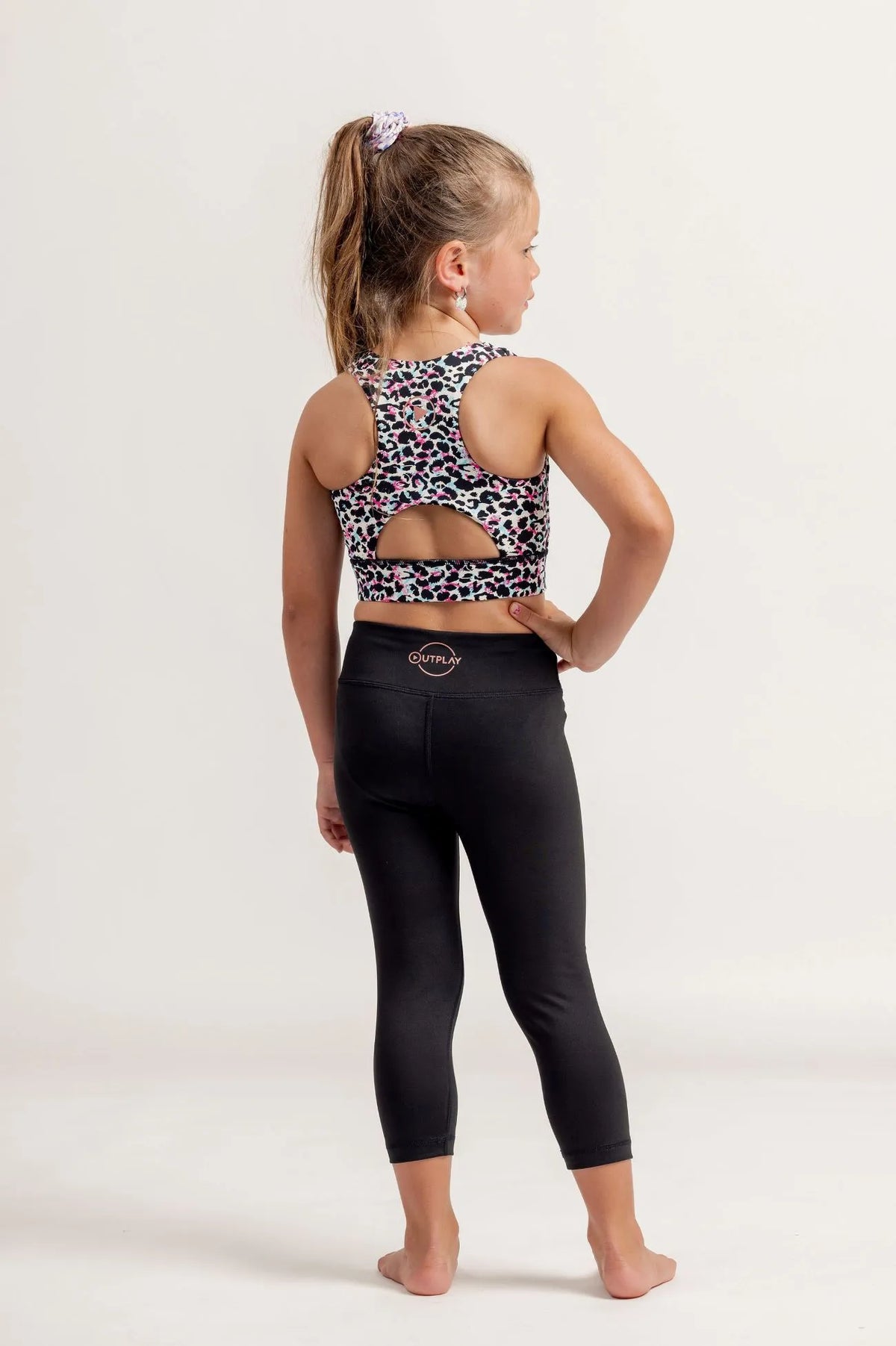 Young girl wearing a Multi coloured leopard print crop top and black Go Get Em 3/4 leggings on a white background