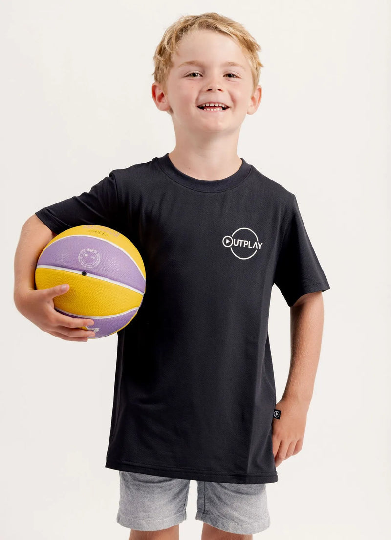 Child wearing a Gametime black t-shirt with 'Outplay' logo holding a purple and yellow ball.